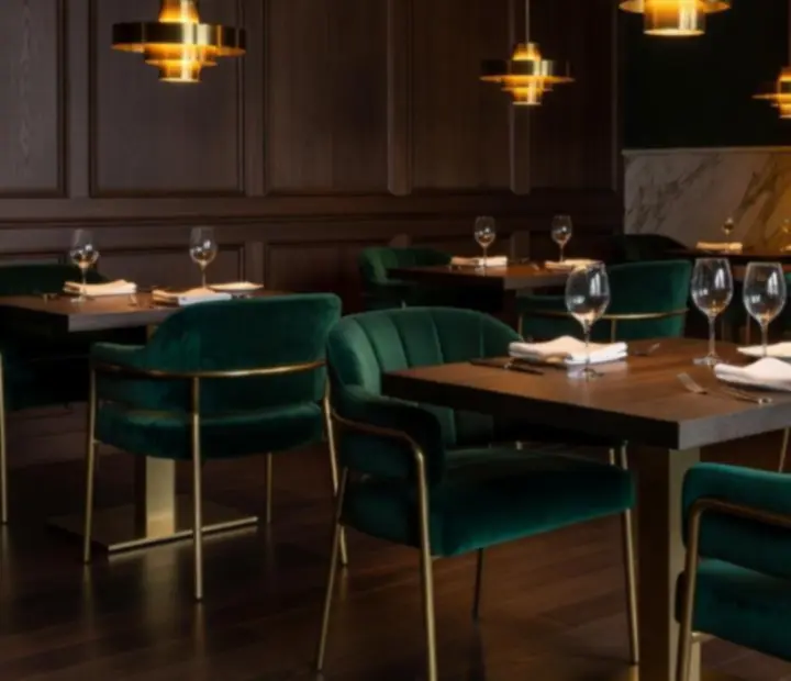 Emerald velvet dining room at Wonderstar s. r. o. with soft amber lighting and elegant table settings.